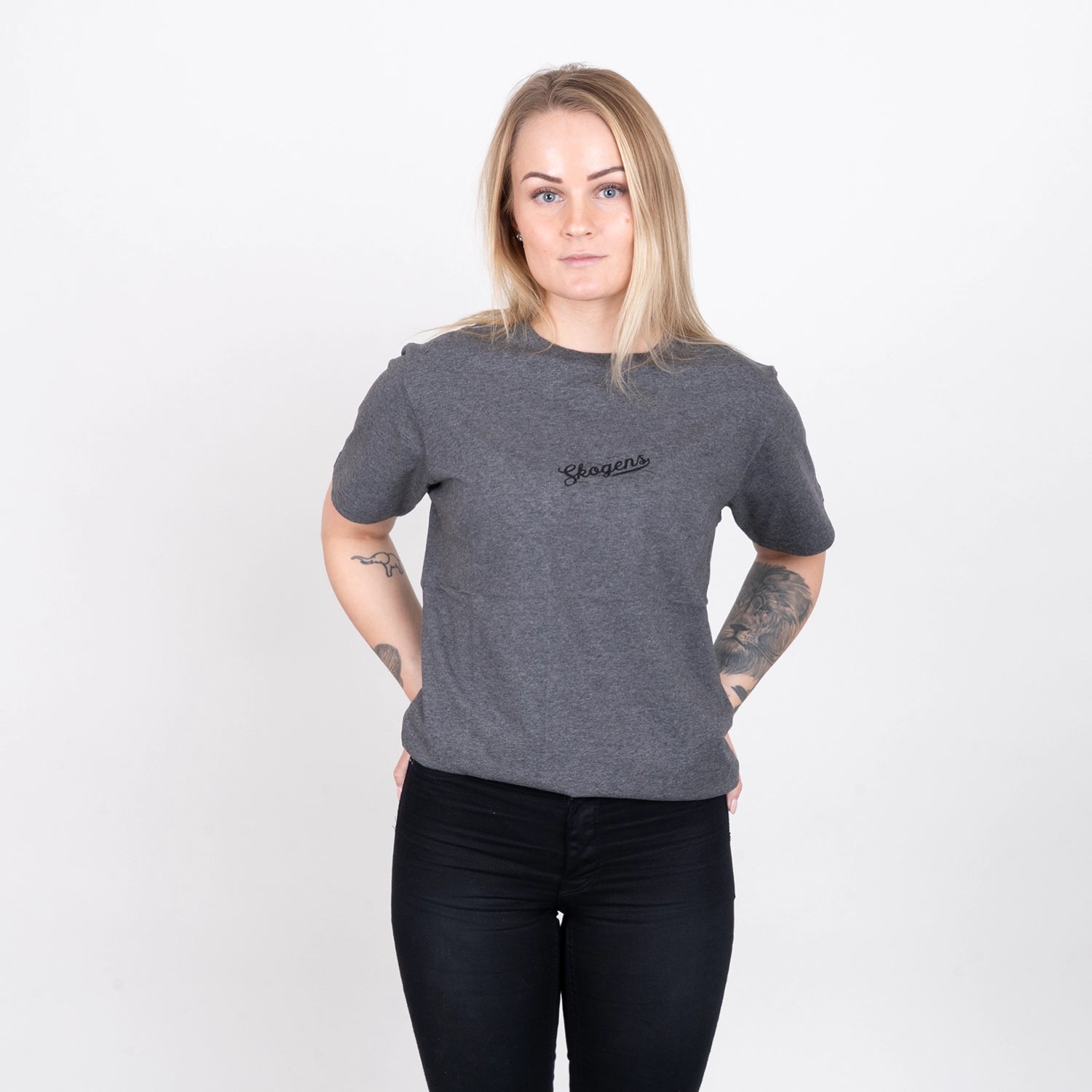 Kvinna i grå t-shirt med texten 'Skogens', grillkläder, enkel vit bakgrund