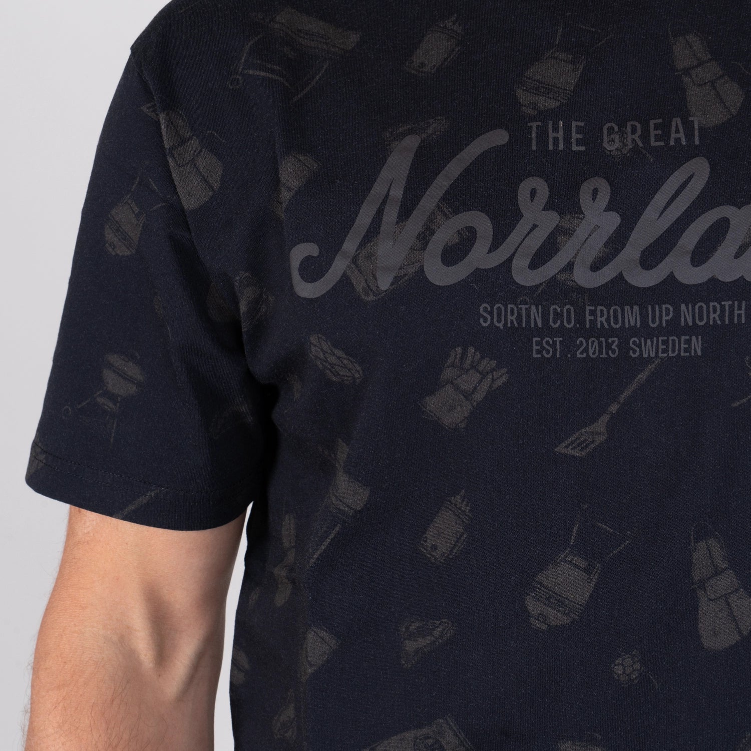 Svart t-shirt med grillmotiv, texten 'The Great Norrland' och grilltillbehörsmönster