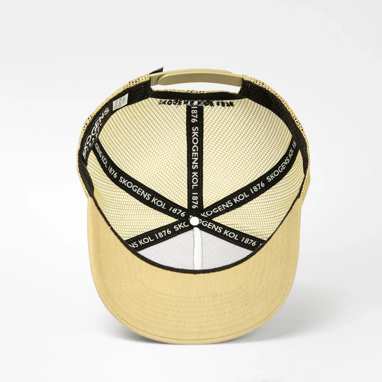 Beige truckerkeps med mesh och texten 'SKOGENS KOL 1876' på svarta band inuti.