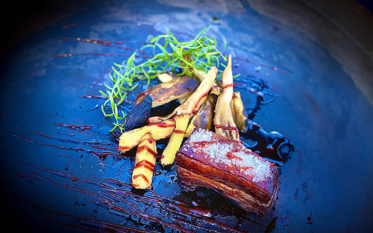 Fläsksida rimmad med grovsalt, citron, salviaolja samt grillbakad potatis, aubergine och kolad ingefära serverad med Tjärlakrits sås