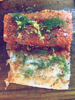 Laxfilé kryddad med citronskal, dill och grillkryddor på träskärbräda