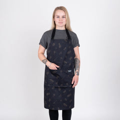 Person med helsvart grillförkläde med grillmönster står mot vit bakgrund
