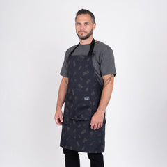 Man i grå t-shirt bär svart grillförkläde, perfekt för utomhusmatlagning och BBQ.