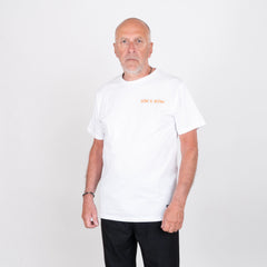 Man i vit t-shirt med texten 'LOW & SLOW', poserar mot vit bakgrund.