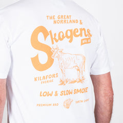 Vit t-shirt med orange tryck av ko och text om BBQ, premium grill och slow smoke.