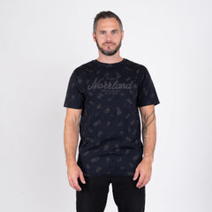 Man i svart t-shirt med Norrland-tryck och grillmönster mot vit bakgrund