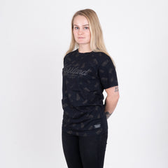 Kvinna i svart t-shirt med grillmotiv och subtil Norrländ-design mot vit bakgrund