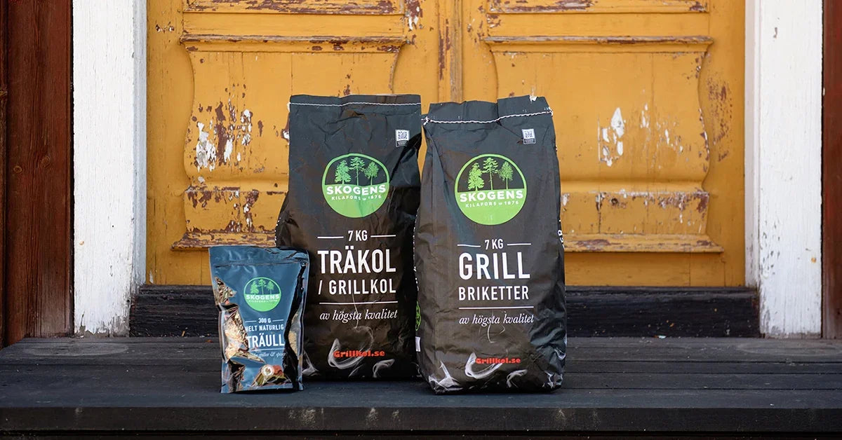 Tre påsar grillkol, grillbriketter och träull utanför en gul dörr, perfekta för grillning.