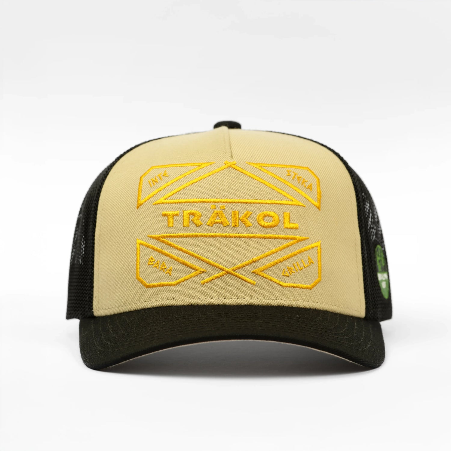 Beige och svart keps med gul brodyr och texten TRÄKOL, grill och kolaccessoar.