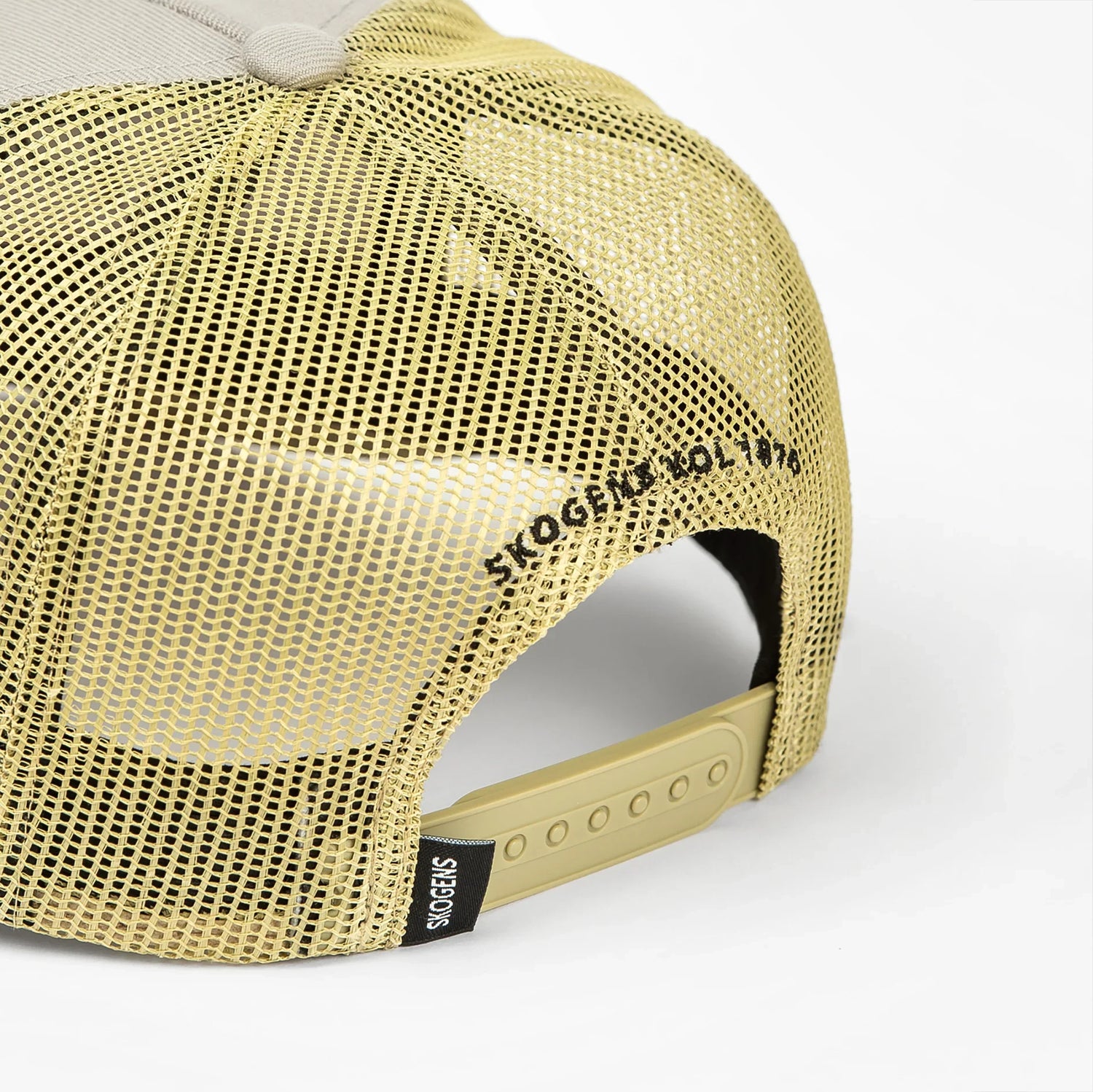 Beige mesh truckerkeps med justerbar plastrem bak och texten 'SKOGENS KOL 1910'.